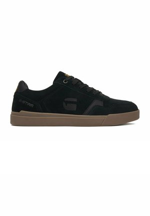 Czarny niski sneaker z brązową podeszwą, logo G-Star na boku i pięcie oraz czarne sznurówki na białym tle.