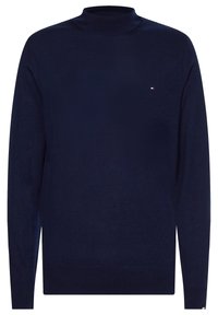 Pull à col roulé bleu marine en tissu tricoté lisse. Il présente des manches longues, une coupe ajustée et un petit logo sur la poitrine.