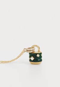Halsband i guldton med en grön hänglåsberlock som har tre diamantlika detaljer och en texturerad kedja. Elegant och unik design.