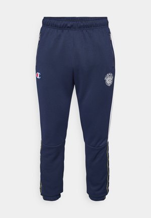 Pantalons de jogging navy en tissu doux, avec ceinture élastique, poches zippées et accents latéraux en vert, jaune et rouge.