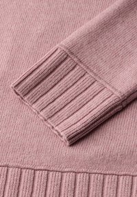Helles rosa gestricktes Sweatshirt mit geripptem Muster an den Bündchen und dem Saum. Weicher Stoff mit sichtbaren Stichmustern.