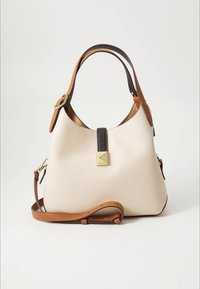 Kermaanmakuinen nahkalaukku, jossa tummanruskea yläkahva, säädettävä olkahihna ja kultasävyinen neliönmuotoinen lukko.