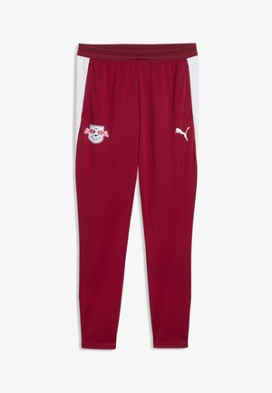 Weinrote Sporthose mit weißen Seitenstreifen, RB Leipzig Logo am linken Oberschenkel und weißes Puma Logo am rechten Oberschenkel.