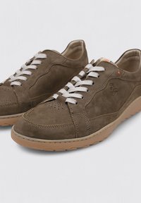 Zapatillas de ante marrón con cordones blancos, detalles perforados en la punta y una suela de goma color beige claro. Presenta un diseño cosido.