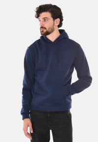 Felpa blu navy realizzata in morbido cotone misto, con tasca kangaroo frontale, cordini regolabili e polsini a coste.