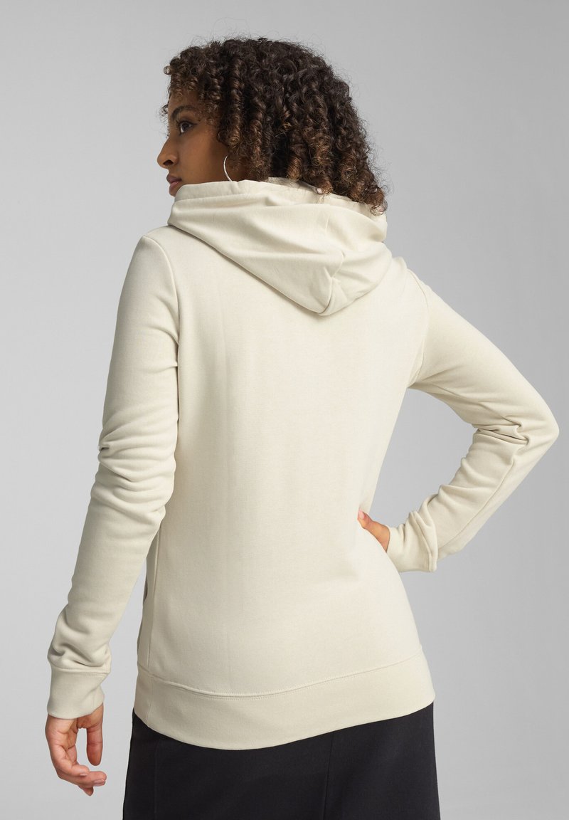 Sudadera beige hecha de una tela suave, con un corte holgado, mangas largas, capucha con cordón y puños y dobladillo de canalé.