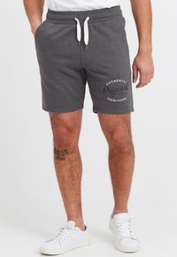 Gray cotton blend shorts with a drawstring waist, featuring white print reading "Authentic Original Denim Goods." Worn with white sneakers.