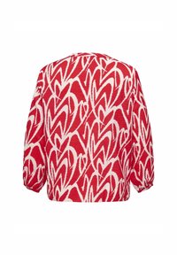 Röd blus med vita hjärt-mönster, långa ärmar och en strukturerad tyg. Baksidan har en avslappnad passform med samlade ärmslut.