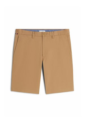 Beige herreshorts til knæet med knap- og lynlås, bæltestropper, sidelommer og et lille rødt, hvidt og blåt mærke på venstre lomme.