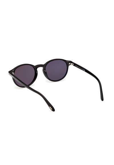 Lunettes de soleil rondes à monture noire avec des verres teintés foncés, présentées en position inclinée vers l'arrière sur un fond blanc.