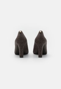 Scarpe con tacco alto marroni a motivo, con una finitura testurizzata, caratterizzate da una punta arrotondata e un accento con logo dorato sul tacco.