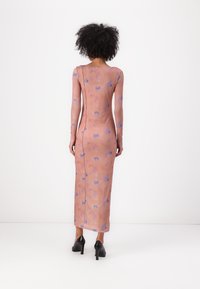 Long-sleeve, form-fitting dress in light pink with blue butterfly patterns, featuring a straight silhouette and back zipper detail.