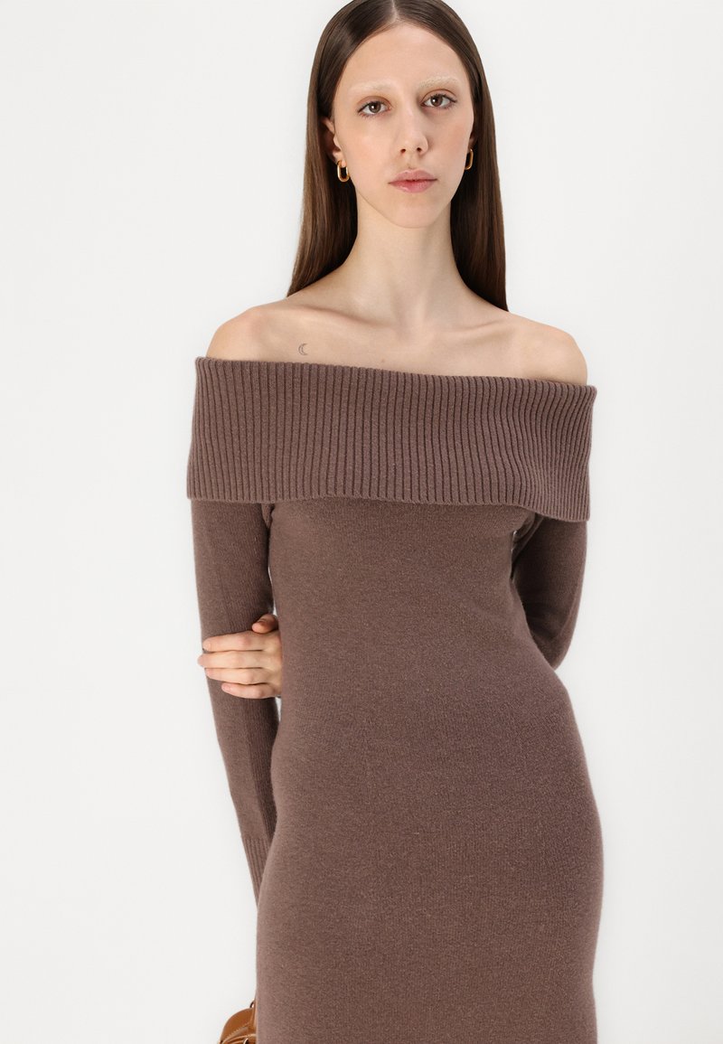 Braunes, schulterfreies Strickkleid mit Rippstruktur, enganliegender Silhouette und langen Ärmeln, das einen glatten, weichen Stoff präsentiert.