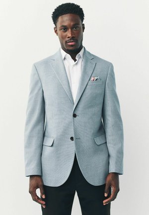 Light blue blazer made of textured fabric, featuring two front pockets, a single breast pocket with a patterned handkerchief, and dark buttons.