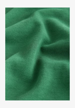 Rohelisest puuvillasest kangast, millel on sile tekstuur, vöötkujuline mustriga ja kerge läige looduslikust valgusest; voltitud õrnades kõverates.