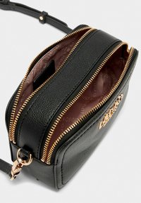 Borsa a tracolla nera in pelle con doppie tasche con zip, hardware dorato e rivestimento interno liscio. Presenta una forma rettangolare compatta.