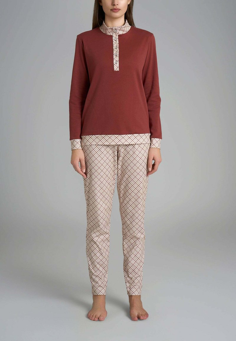 Completo in cotone per il tempo libero con maglia a maniche lunghe color ruggine, con collo abbottonato, e pantaloni crema con motivo a griglia di diamanti marroni.