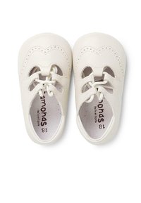 Scarpe bianche in pelle con punta arrotondata, dotate di perforazioni decorative, chiusura con lacci e un morbido rivestimento interno. Taglia 18.