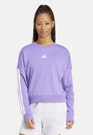 Sudadera lila de tejido suave con un corte holgado, que presenta rayas blancas en las mangas y un pequeño logo blanco en el pecho.