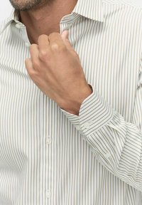 Witte button-up shirt met dunne verticale groene strepen, voorzien van een klassieke kraag, verstelbare manchetten en een gladde stoftextuur.