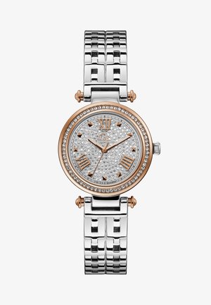 Rund sølvfarvet ur med en diamantsmykket urskive, rosaguld accenter og et metalarmbånd. Har romerske tal som markører.