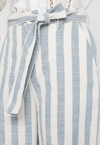 Linnenmix broek met lichtblauwe en witte verticale strepen, voorzien van een strikband in de taille en zijzakken.