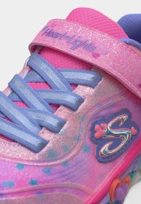 Παιδικό αθλητικό παπούτσι σε ροζ και μοβ χρώμα με μπλε κορδόνια, λαμπερά καρδιές, λουράκι "Heart Lights" και πολύχρωμη σόλα με λογότυπο "S" στο πλάι.