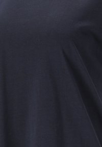 Mörkblå bomull T-shirt med en mjuk textur, lös passform och subtil drapering. Inga synliga mönster eller hårdvara finns.