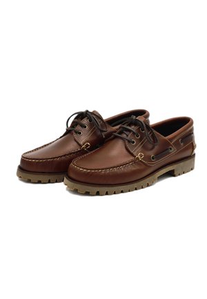 Bruine leren bootschoenen met een ronde neus, gestikte details en een rubberen zool met antislippatronen. Bruine veters en oogjes inbegrepen.
