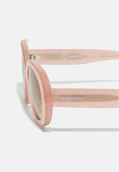 Lunettes de soleil Burberry roses avec une monture épaisse, texture pailletée sur les branches et verres teintés marron. Logo intégré sur la pièce de temple.