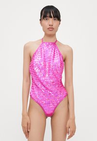Maillot de bain une pièce en sequins roses avec un design à col halter. Présente une silhouette ajustée et une texture brillante avec une finition de couleur vive.