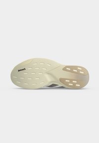 Semelle de chaussure avec bande de roulement en caoutchouc beige et marron clair, motifs rectangulaires découpés et logo Continental visible à l’avant-pied.