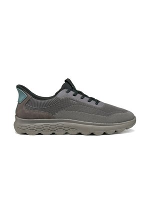 Chaussure de sport grise avec dessus en mesh, lacets noirs, col rembourré et semelle épaisse et coussinée avec motif ondulé sur le côté.