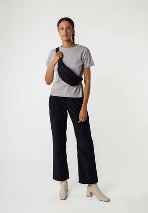 Gray cotton t-shirt paired with black corduroy wide-leg pants. Accessory includes a black waist bag worn across the body. Beige block-heeled boots.