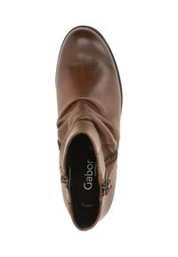 Brown leather ankle boot with a slouch design, featuring side zippers and a smooth, shiny finish. Soft interior lining and textured sole.