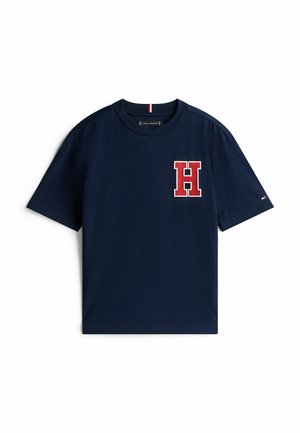 T-shirt a maniche corte blu navy con un grande logo rosso "H" sul lato sinistro del petto e colletto rotondo. Realizzato in morbido cotone.