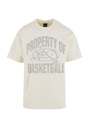Krēmos krāsas kokvilnas T-krekls ar lielu pelēku grafiku, kurā rakstīts "PROPERTY OF k1x BASKETBALL" treknā sportiskā fontā. Īsās piedurknes, noapaļots kakla izgriezums.