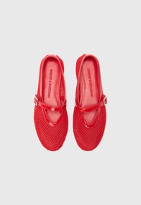 Pantoufles de ballet en maille rouge avec une finition brillante, dotées d'une sangle au milieu du pied et d'un bout arrondi. Conçues pour la respirabilité et le confort.