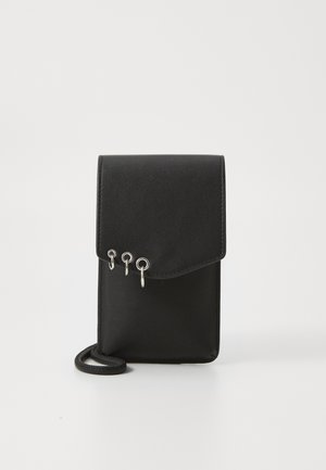 Bolso cruzado de cuero negro con cierre de solapa, que presenta tres anillas de metal plateado como adornos y una correa delgada. Textura suave.