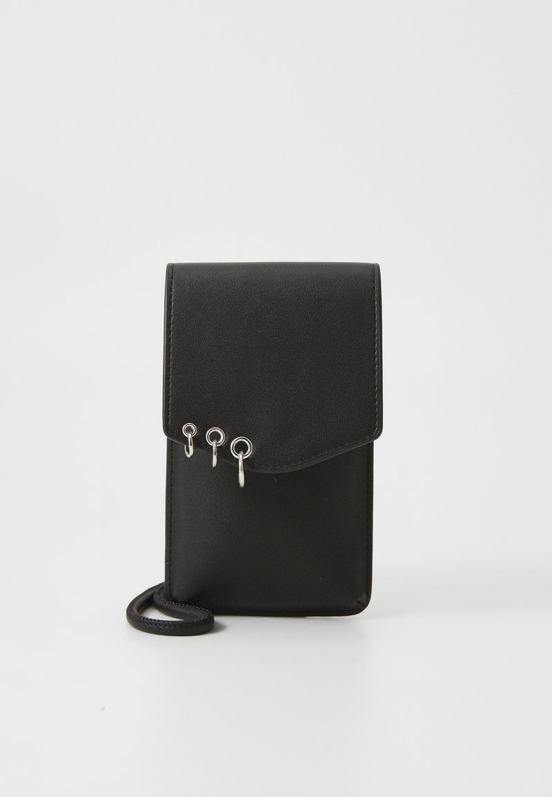 Black leather crossbody bag with a flap closure, featuring three silver metal rings as accents and a thin strap. Smooth texture.