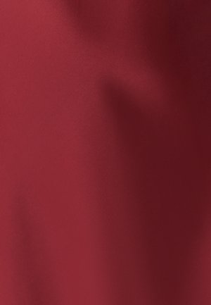 Tessuto rosso con una superficie liscia e opaca. La superficie presenta sottili variazioni di tonalità, creando profondità e una leggera lucentezza.