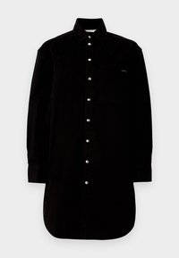 Camicia nera in cotone con colletto, maniche lunghe, chiusura a bottoni e taschino sul petto. Presenta bottoni argentati e un orlo curvo.