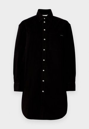 Zwarte katoenen shirt met een kraag, lange mouwen, knoopsluiting aan de voorkant en een borstzak. Het shirt heeft zilveren knopen en een rondlopende zoom.