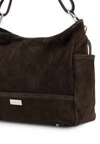 Brown suede handbag with a soft texture, a silver logo plate, and side pockets. Features sturdy straps and a spacious, rounded design.