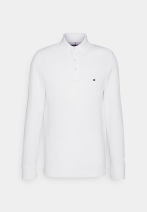 Polo shirt bianco a maniche lunghe, in materiale cotone, con patta a bottoni, colletto classico e piccolo logo sul petto. Design semplice.