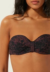 Bandeau bikiny top s leopardím vzorem z hladké tkaniny, s uzlem uprostřed a bezšvovým provedením. Tóny tmavě hnědé a černé.