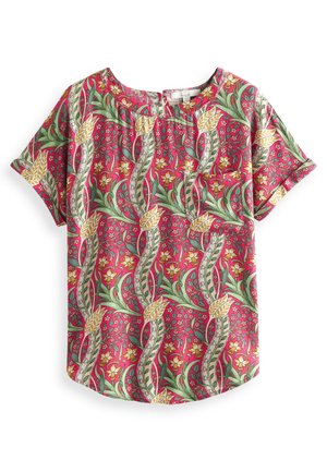 Blouse à manches courtes avec un fond rouge et un motif floral de vigne en vert, jaune et blanc, avec un col rond et un dos en forme de trou de serrure.