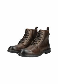 Botas de cuero marrón hasta el tobillo con puntera negra redondeada, cierre de cordones en la parte delantera y cremallera, con ojales de bronce y tirador.