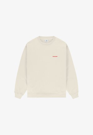 Bēšs džemperis ar apaļu kakla izgriezumu, garām piedurknēm un nelielu sarkanu "POCKIES" logotipu kreisajā krūtīs.