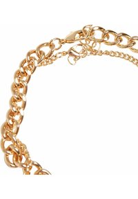 Armbånd i gullfarget metallkjede med tykke, sammenflettede lenker og et justerbart lås med en liten kjedeutvidelse. Glatt, blank overflate.